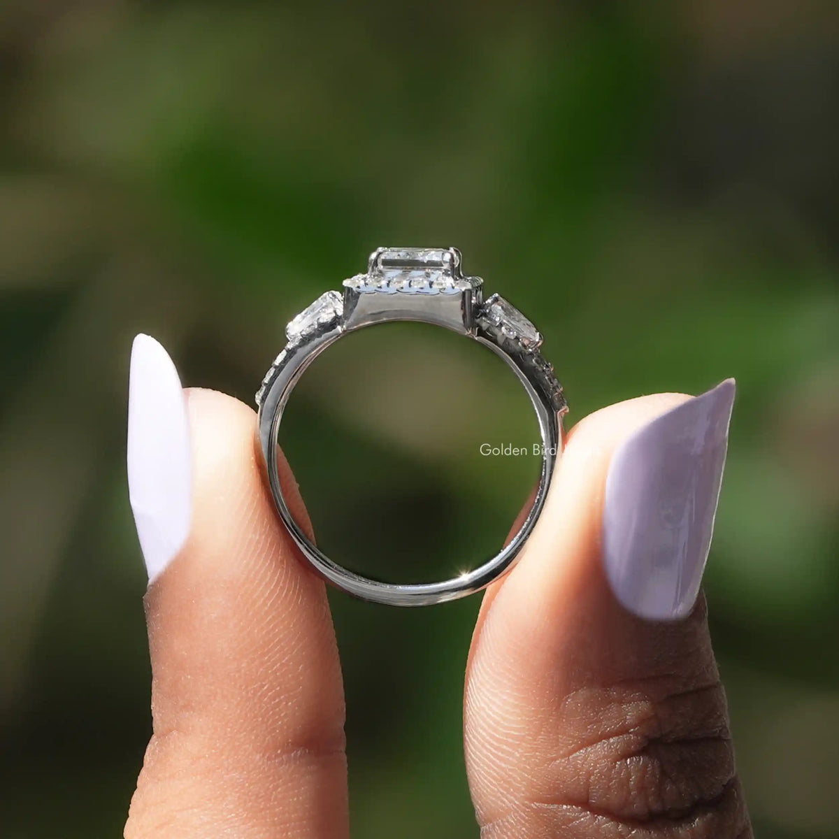 Back View of Princess Cut Three Stone Halo Engagement Ring In two fingers