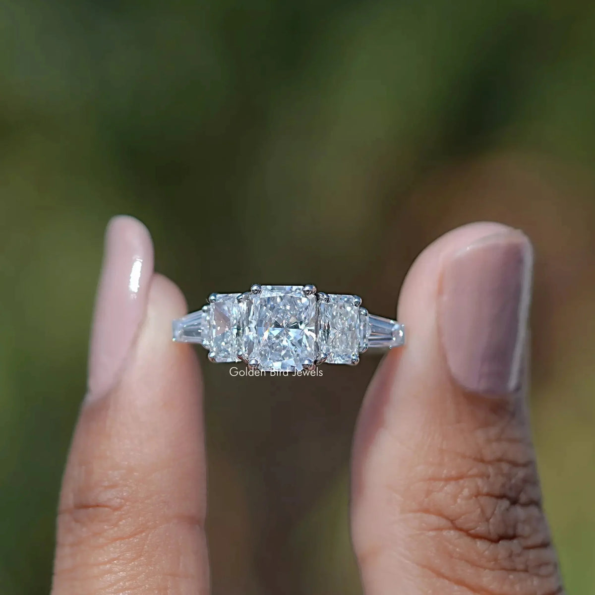 Front View of Radiant Cut Lab Grown Diamond Five Stone Ring In two Fingers