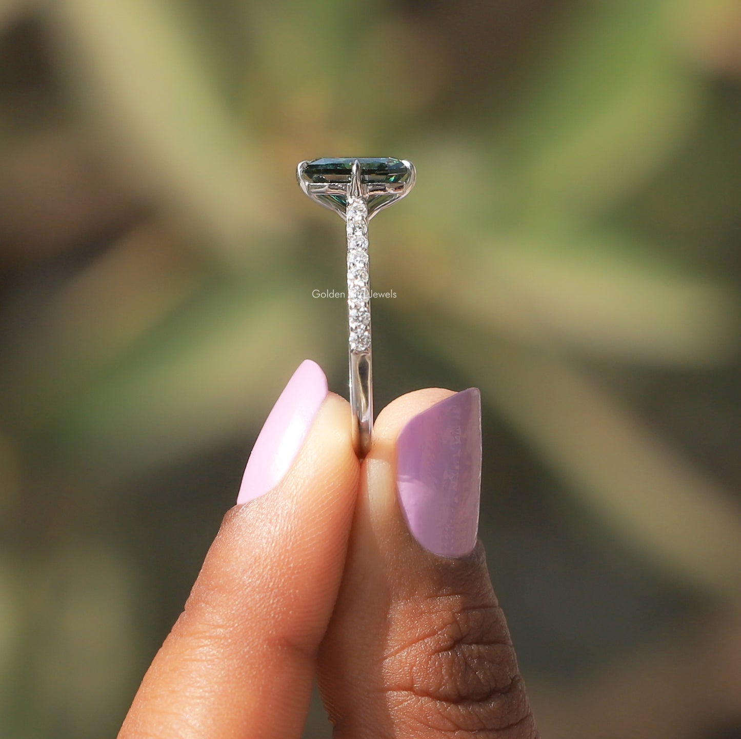 Side View of Green Radiant Cut Moissanite Ring In two fingers