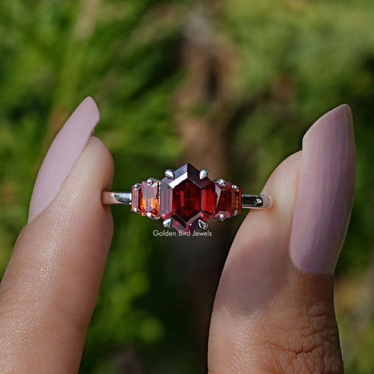 Front View of Red Ruby Hexagon Cut Gemstone Ring In two Fingers