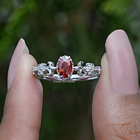 Two fingers holding the Ruby Oval Cut Gemstone Accent Stone Ring