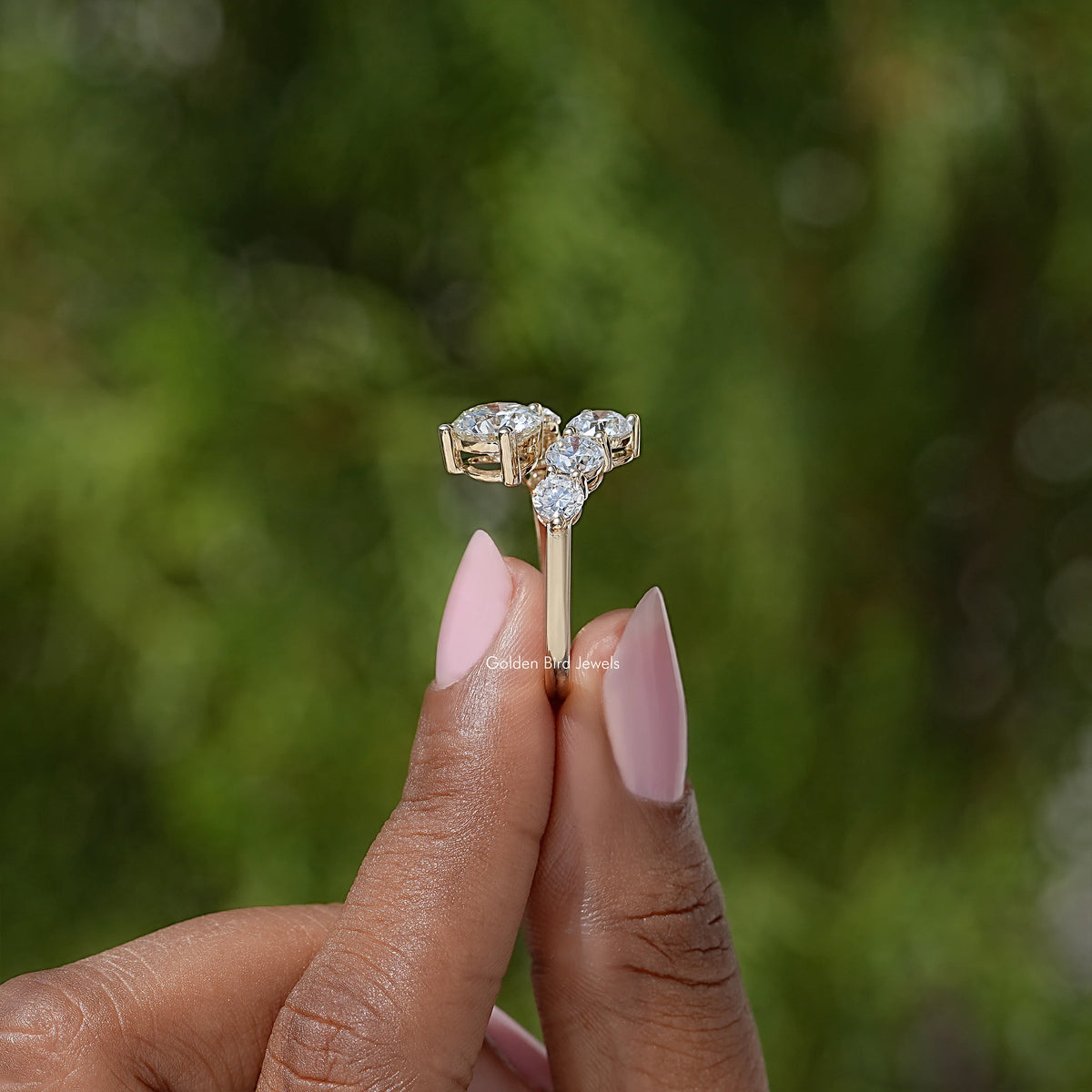 Gold-tone bypass shank ring with a cluster of round stones in a boxed setting