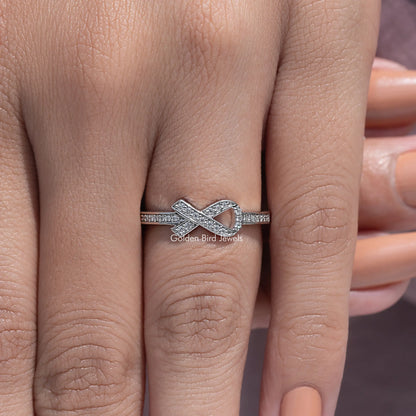 Silver hope ring featuring a bow-like cross motif with round-cut stones