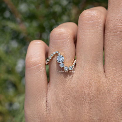 Gold wave wedding band featuring round stones, close-up view on fingers