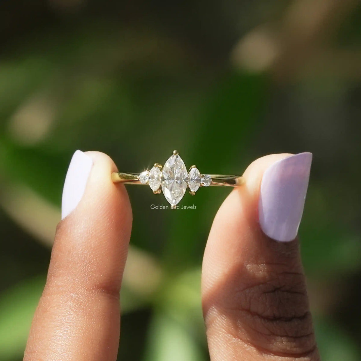 Two fingers holding the Marquise Cut Moissanite Ring