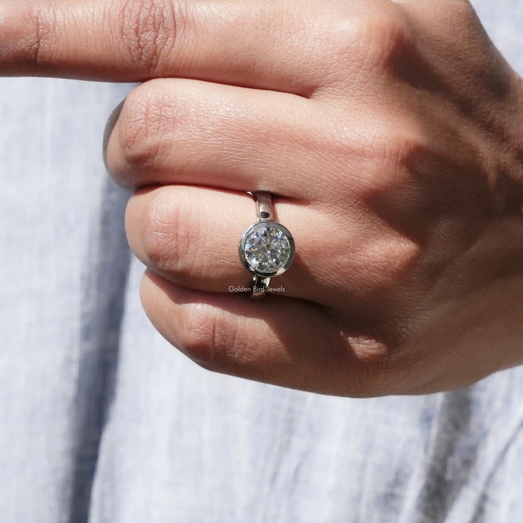 View of Round Cut Moissanite Bezel Set Engagement Ring in Finger