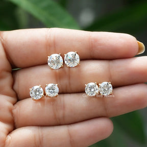 View of multi-carat moissanite stud earrings in holding hand 