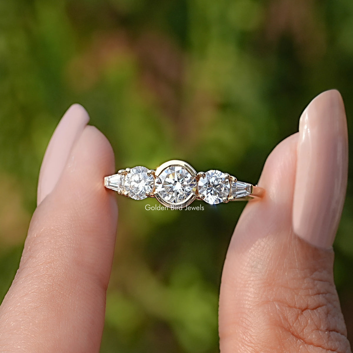 Two fingers holding the Round Cut Lab Diamond Five Stone Ring