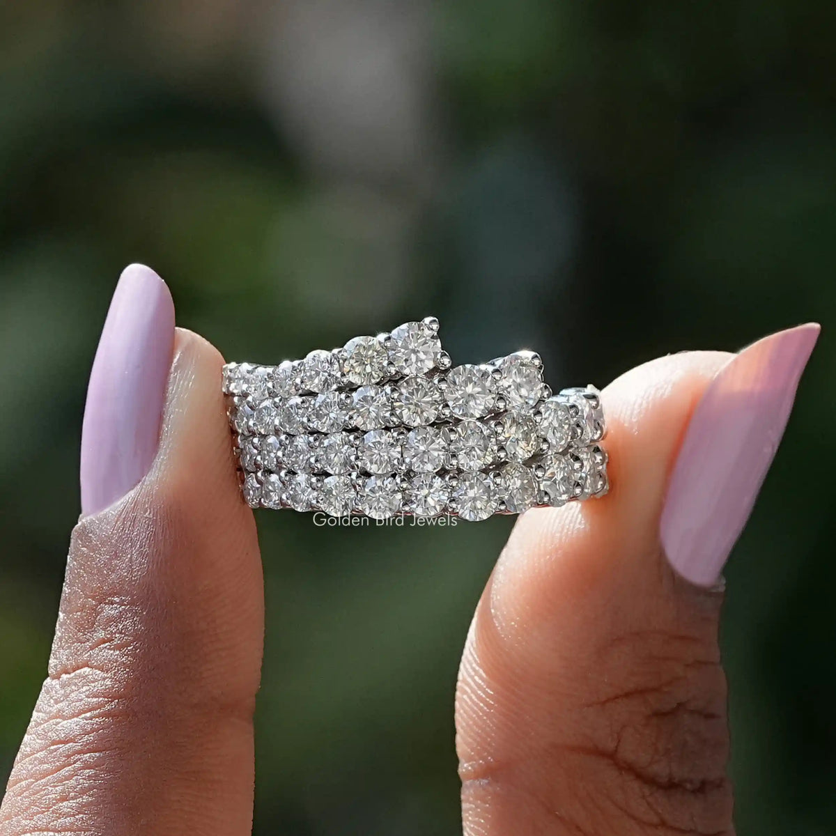 Two fingers holding the Round Cut Moissanite Half Eternity Wedding Band