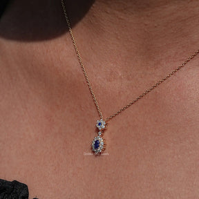 Clear view of Sapphire Blue Oval Cut Gemstone Halo Pendant in wear women' s