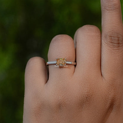 Yellow emerald-cut solitaire ring on silver-tone band, hand-worn side view