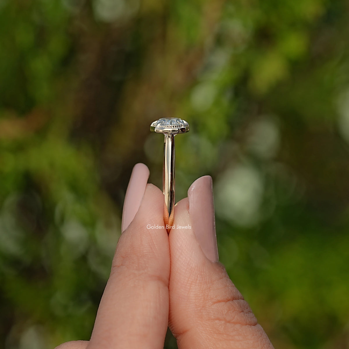 Gold-tone solitaire ring with tall prongs holding an oval center stone