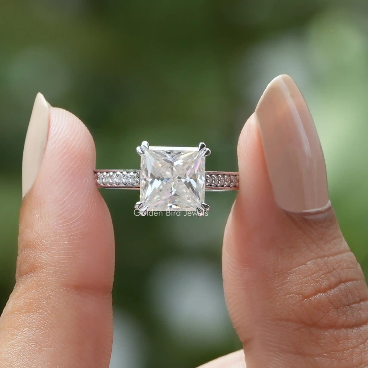 Two fingers holding the Princess Cut Moissanite Engagement Ring
