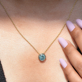 In neck view of aqua blue moissanite halo pendant 