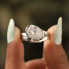 Two fingers holding the Step Cut Oval Bypass Ring 