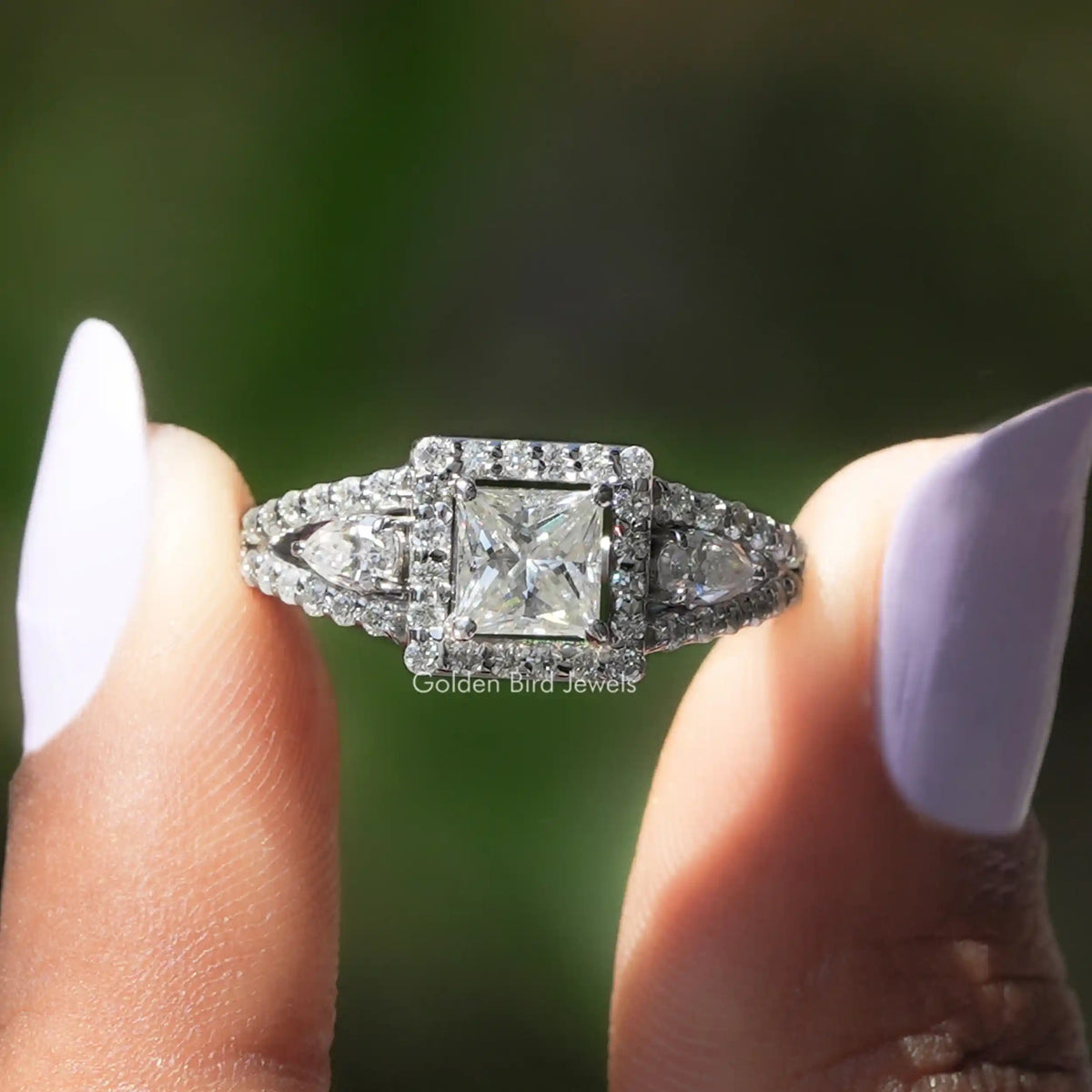 Front View of Princess Cut Halo Moissanite Engagement Ring In two Fingers