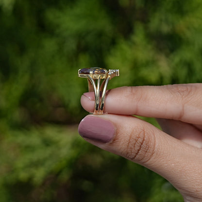 Gold-tone ring seen from side, with prongs holding a pear-cut center stone