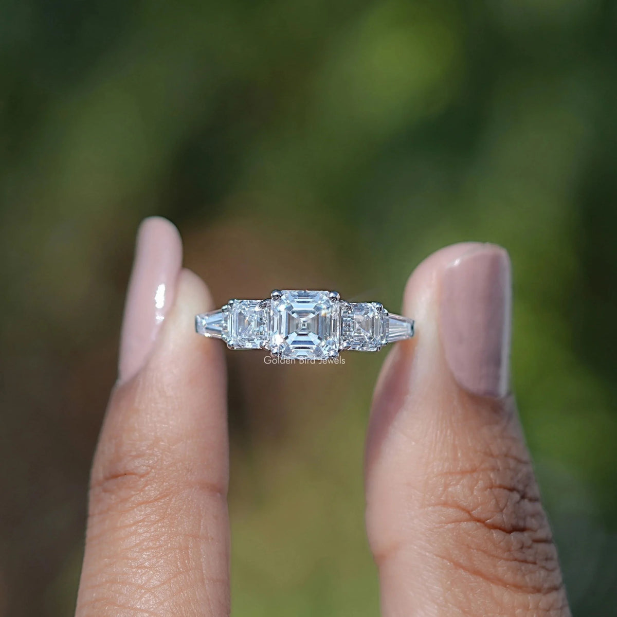 Front View of Asscher And Tapered Baguette Cut Five Stone Ring In two Fingers