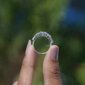 Back View of Round And Tapered Baguette Five Stone Ring In two fingers