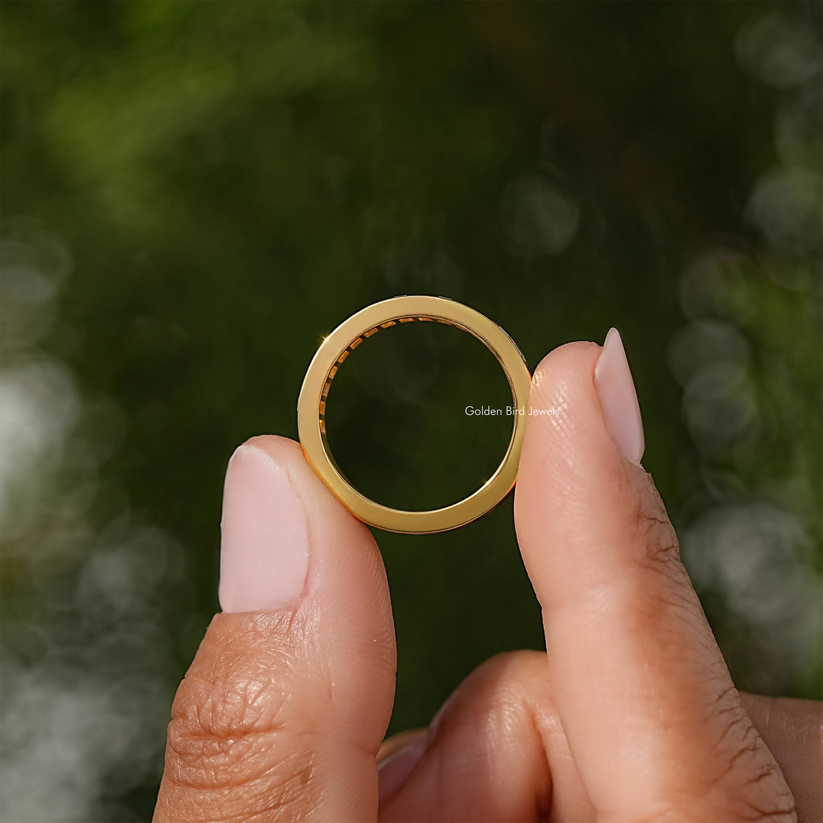 Yellow gold channel-set ring band with baguette-cut moissanite stones, side view