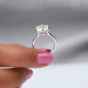 Back View of Moissanite Hexagon Cut Solitaire Engagement Ring In two fingers