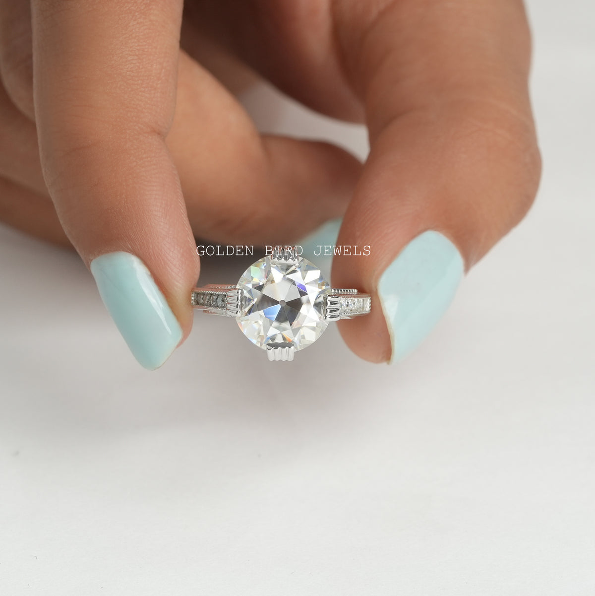 Front View of OEC Round Cut Vintage Moissanite Engagement Ring In two Fingers
