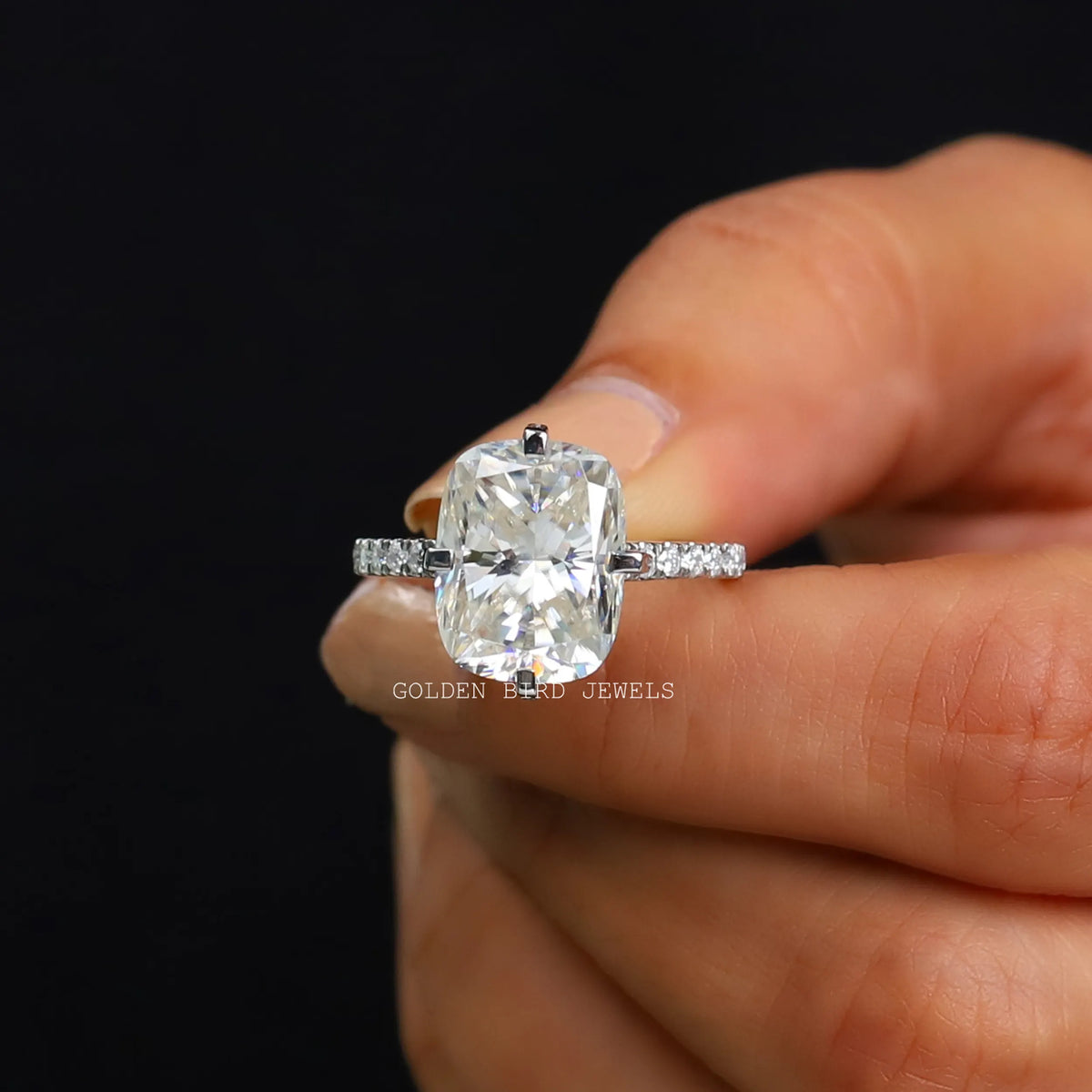 Front View of Moissanite Cushion Cut Solitaire Ring In two Fingers