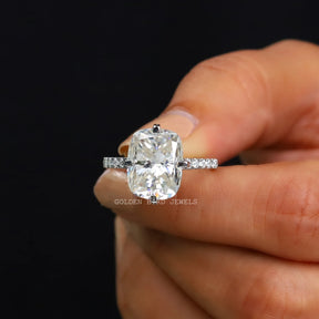Front View of Moissanite Cushion Cut Solitaire Ring In two Fingers