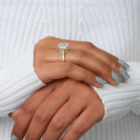 In a finger Side view of a moissanite  halo engagement ring 
